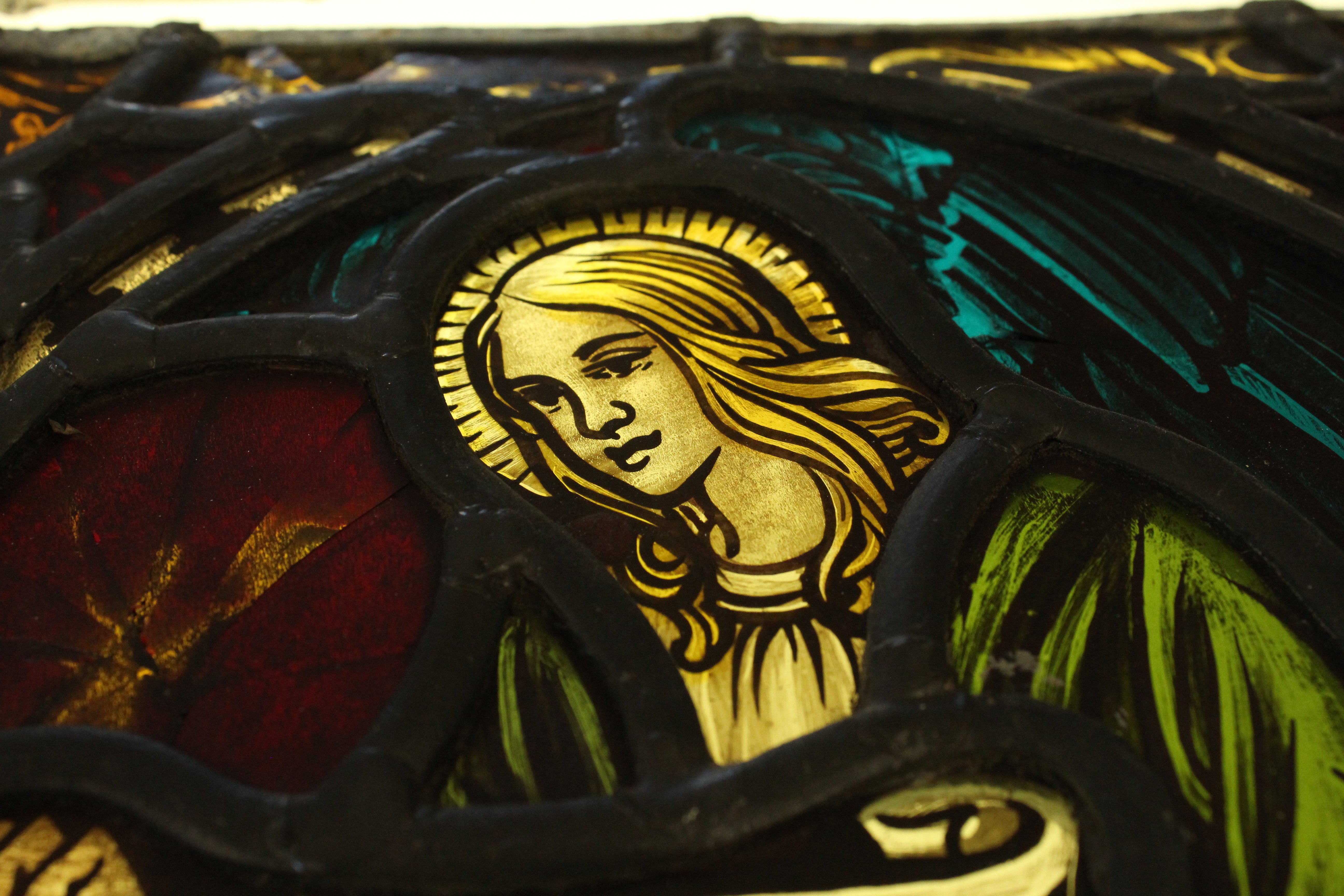 Detail of the face of the angel in the right stained glass panel.